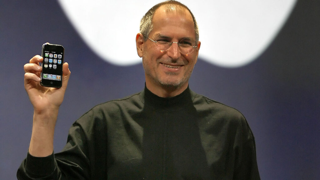 Steve Jobs, vestindo sua famosa camisa preta de gola alta durante o lançamento do iPhone, onde ele fez uso de analogia para facilitar a compreensão do público